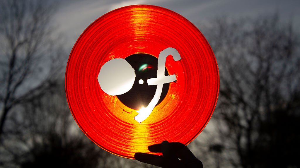 the word of cut out of a red vinyl record , then put in the sky towards the sun for better contrast